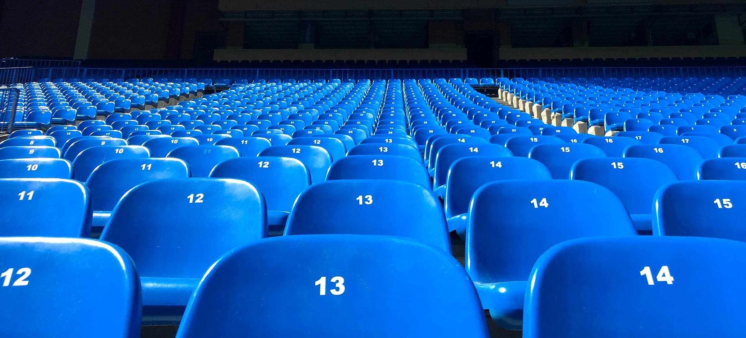 Rows of empty blue numbered stadium seats waiting for matchday