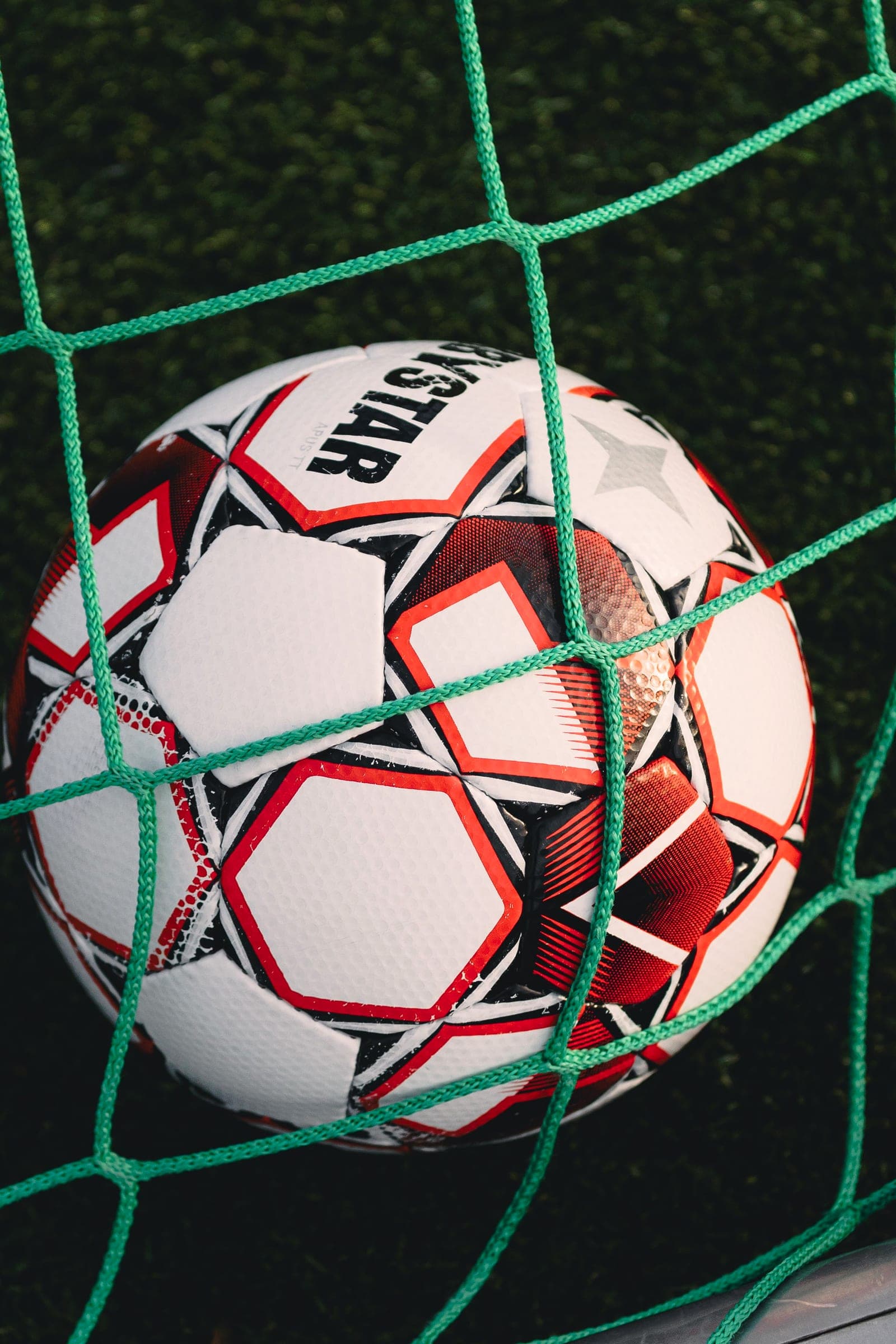 Football caught in the goal net, close-up